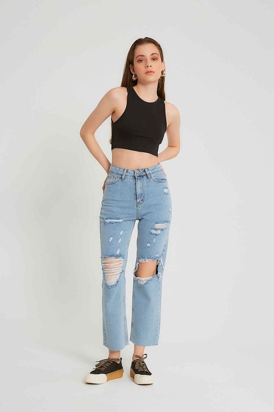 Model in een spijkerbroek met hoge taille, lichtblauw en gescheurd, met wijde pijpen en rafelige zoom.