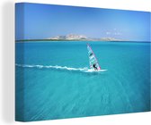 Canvas Schilderij Een windsurfer surft in het heldere water - 60x40 cm - Wanddecoratie