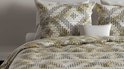 Housse de couette et taies d'oreiller avec motif géométrique vert, beige et noir. Ressemblent à un filet de pêche.