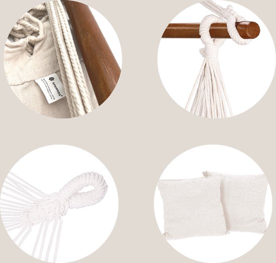 Close-up van witte hangstoel: label, houten spreidstok met touw, lus en twee kussens.