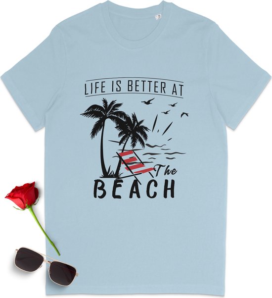 T-shirt bleu clair avec inscription 'LIFE IS BETTER AT THE BEACH', palmiers et une chaise de plage. Lunettes de soleil et rose rouge à côté.