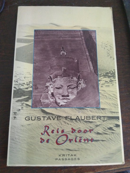 Livre avec sur la couverture une statue en plâtre d'un pharaon dans le sable du désert. "Reis door de Oriënt" par Gustave Flaubert.