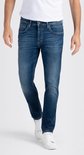 Man met een blauwe jeans, wit T-shirt en witte sneakers.
