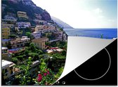 KitchenYeah® Inductie beschermer 71x52 cm - Achter de bloemen valt het dorp Positano aan de Amalfikust te zien - Kookplaataccessoires - Afdekplaat voor kookplaat - Inductiebeschermer - Inductiemat - Inductieplaat mat