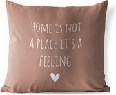 Sierkussen Buiten - Engelse quote "Home is not a place it's a feeling" met een hartje tegen een bruine achtergrond - 60x60 cm - Weerbestendig