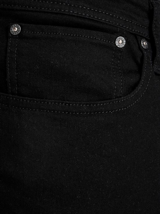Detail van de voorkant van een zwarte jeans met klinknagels en zak.