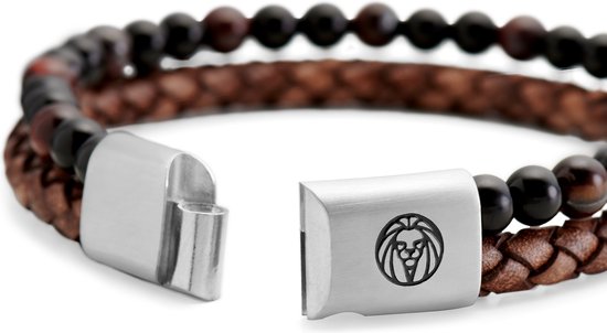 Close-up van een metalen armbandsluiting met een leeuwenlogo, en gevlochten bruin leer.