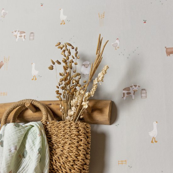 Detail van 'Little Farm' behang met een houten kapstok, mand, gedroogde bloemen en boerderijdieren.