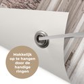 Detail van een tuinposter met een metalen ring voor eenvoudige bevestiging. Tekst: 'Makkelijk op te hangen door de handige ringen'.