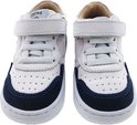 Witte leren sneakers met donkerblauwe suède accenten en klittenbandsluiting.