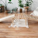 Houten klimrek met twee glijbanen, op een kleed tussen planten.