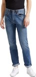 Man in een lichtblauwe jeans met opgerolde broekspijpen, gedragen met witte sneakers.