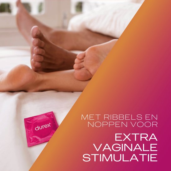 Close-up van de voeten van een stel in bed. Een roze Durex condoom verpakking ligt op het bed.