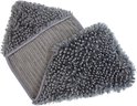 Een grijze, pluizige handdoek met een geribbelde textuur en kwastjes aan de randen.