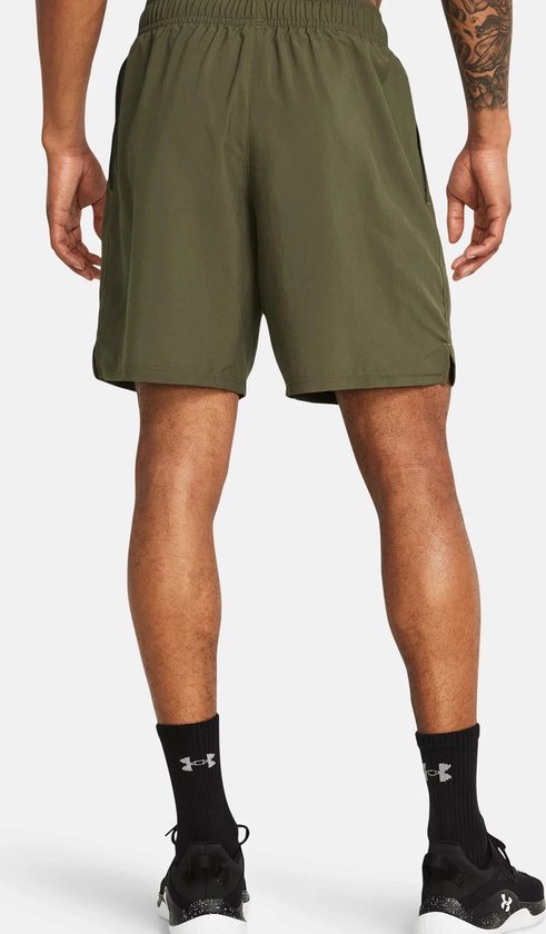 Achterkant van militaire groene sportshort met elastische tailleband, zakken en zwarte schoenen.