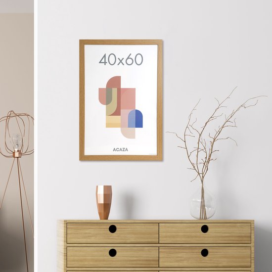 Een houten fotolijst 40x60 cm met een abstract kunstwerk hangt aan een witte muur boven een dressoir.