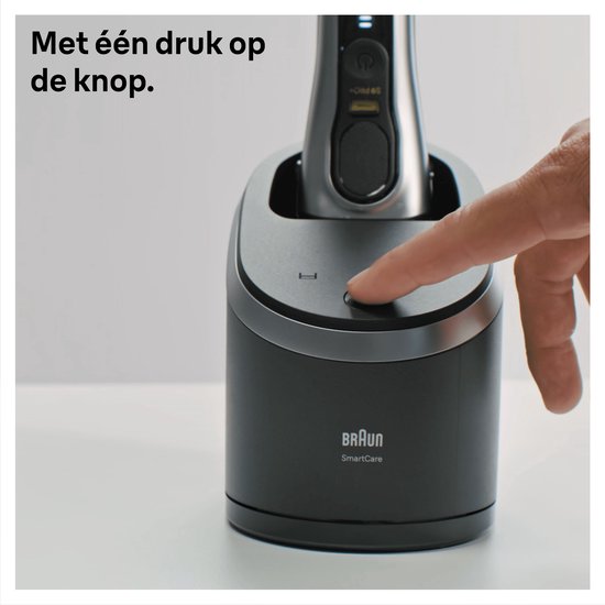 Vinger drukt op de aan/uit-knop van een Braun SmartCare Center, met de tekst 'Met één druk op de knop.'.