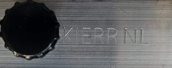 Tekst 'KIERR NL' gegraveerd op een metalen oppervlak.