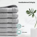 Stapel lichtgrijze handdoeken met een textuur van 100% katoen en een zacht gevoel.