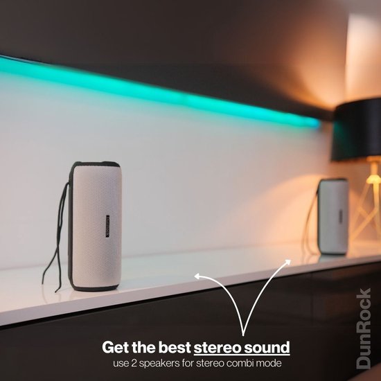Twee grijze DunRock speakers met koord, op een witte plank, met gekleurde verlichting.
