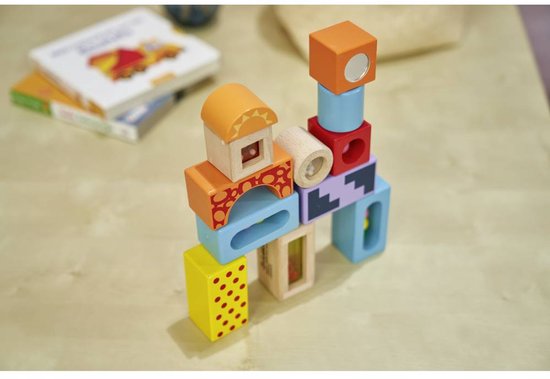 Een stapel kleurrijke houten blokken met geometrische en stippenpatronen.