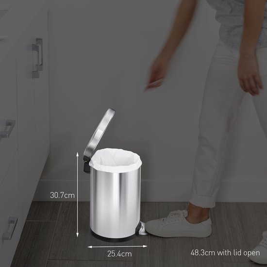 Vrouw met witte sneakers doet een witte vuilniszak in een zilverkleurige prullenbak. Afmetingen aangegeven: 30.7cm hoog, 25.4cm breed, 48.3cm breed met open deksel.