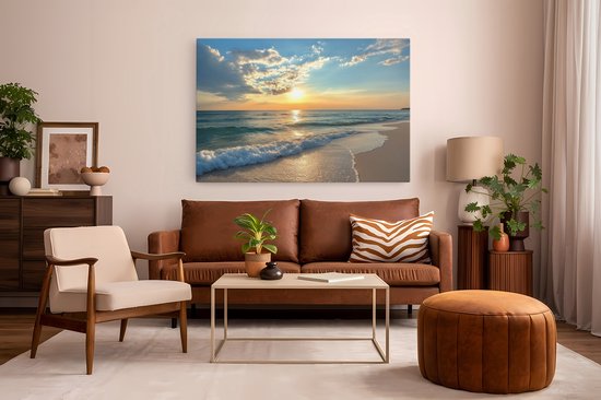 Canvas schilderij van zonsondergang aan zee, boven een bruine bank met een beige fauteuil en bruin poefje.