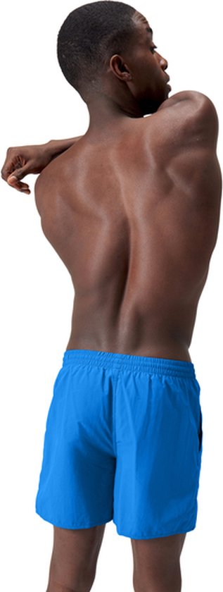 Homme tournant le dos, dos visible, portant un short de bain Speedo bleu vif.