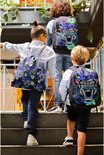 Drie jongens lopen een trap op met rugzakken met tijgerprint.