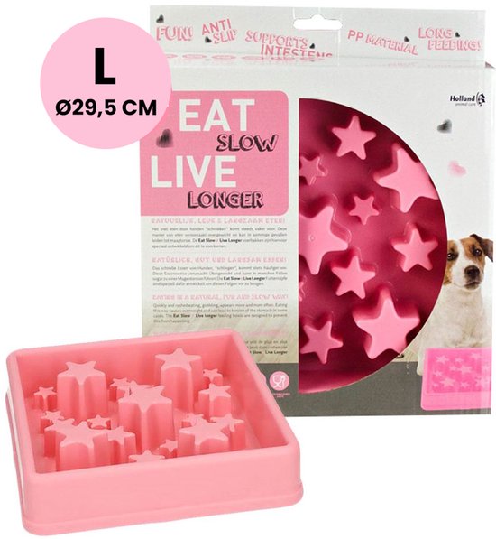 Roze voerbak maat L (Ø 29,5 cm) met stervormige verhogingen, naast de verpakking met een hond. Tekst: Eat Slow Live Longer.