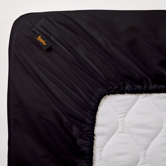 Hoek van een zwart hoeslaken met Superieur label, past strak om een matras.