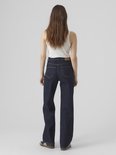 Model van achteren gezien, met wijde jeans in donker denim.