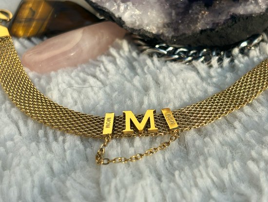 Gouden mesh armband met de letters M, O, M en twee hangertjes.