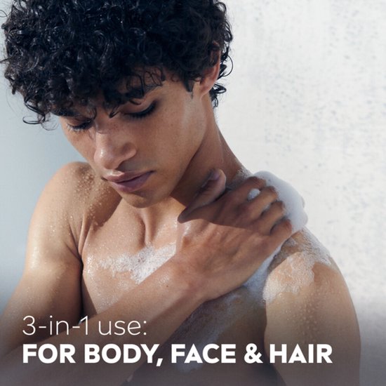 Man met donker, krullend haar, terwijl hij schuim op zijn schouder aanbrengt. Tekst: '3-in-1 use: FOR BODY, FACE & HAIR'.