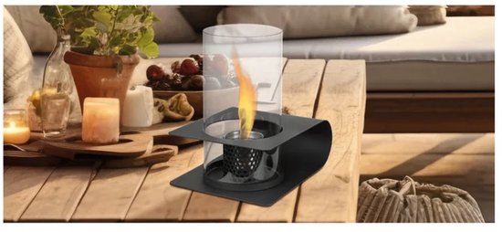 Lanterne noire en métal avec flamme allumée, placée sur une table en bois avec décoration.