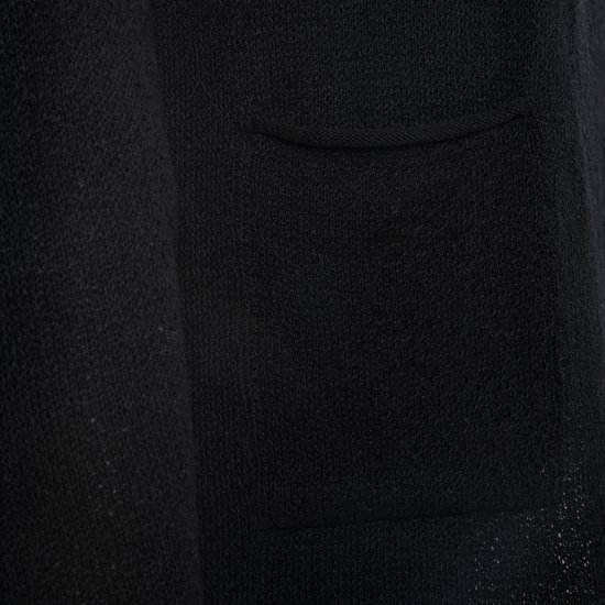 Detail van de gebreide stof van een zwart vest met een zak.