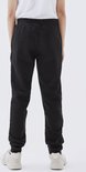 Achterkant van een jongen in een zwarte joggingbroek.