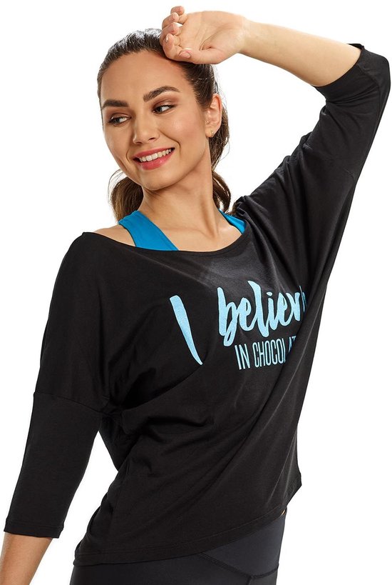 Model draagt een zwart shirt met 3/4 mouwen en blauwe tekst "I believe IN CHOCOLATE". Blauwe sport-bh zichtbaar.