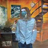 Albumhoes met een man in een lichtblauwe spijkerblouse, staand in een woonkamer. Zijn hoofd is vervangen door een landschap met een stad en de zee.