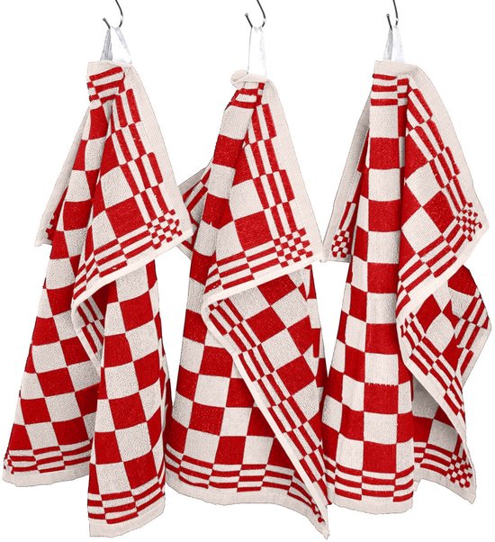 Drie rode en witte geblokte keukendoeken hangen aan haken in een keuken.