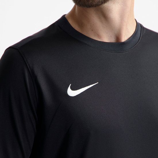 Gros plan d'un homme portant un t-shirt de sport noir, avec un logo Nike blanc sur la poitrine.