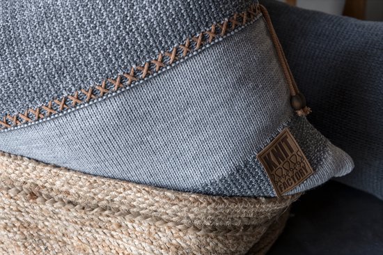 Gedetailleerde close-up van een grijs kussen met een lichte grijze band en gestikte details.