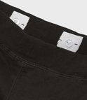 Sluiting met knopen en elastische band aan de binnenkant van de tailleband van een zwarte joggingbroek.