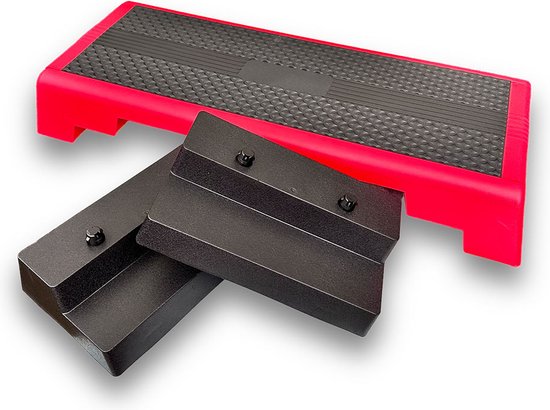 Een rode aerobic step met zwart antislipoppervlak, met twee losse zwarte verhogers ernaast.