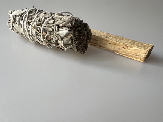 Bundel witte salie gebonden met touw, naast een stuk palo santo hout.