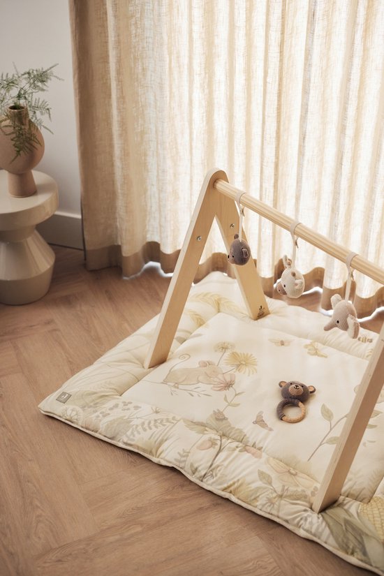 Houten babygym met speelmat met bosprints, met hangende knuffels van een muis, beer en olifant.