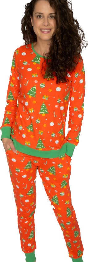 Vrouw in oranje kerstpyjama, met groene boorden, print van kerstbomen, snoepstokken en sneeuwvlokken.