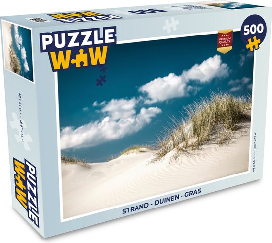 Emballage d'un puzzle de 500 pièces montrant des dunes, de l'herbe et un ciel bleu avec des nuages.