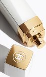 Close-up van de witte Chanel sprayfles met gouden spuitmond en losse gouden dop met CC logo.