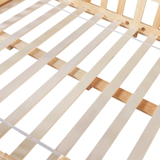 Gros plan du sommier à lattes en bois naturel d'un lit maison.